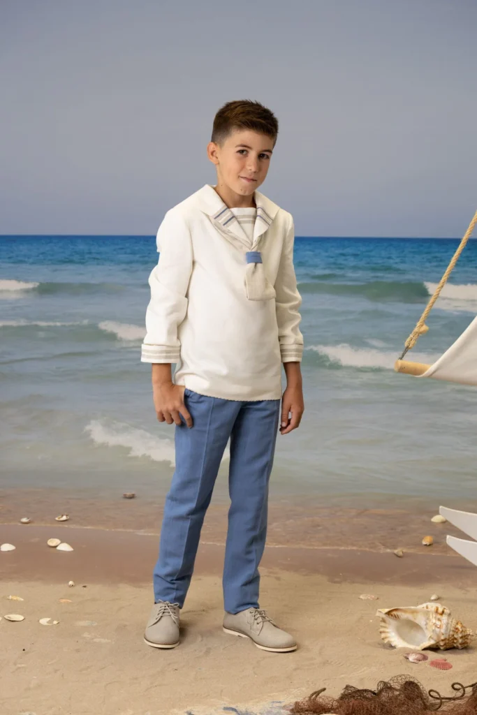 Niño vestido para primera comunión en la playa